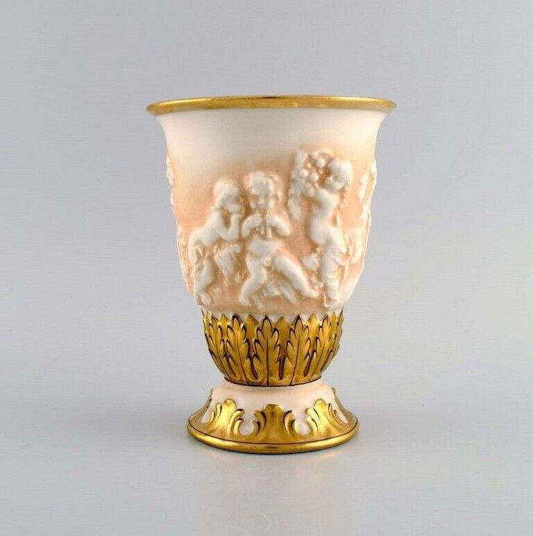 Capodimonte, Italy. Antique porcelain vase with putti in relief.