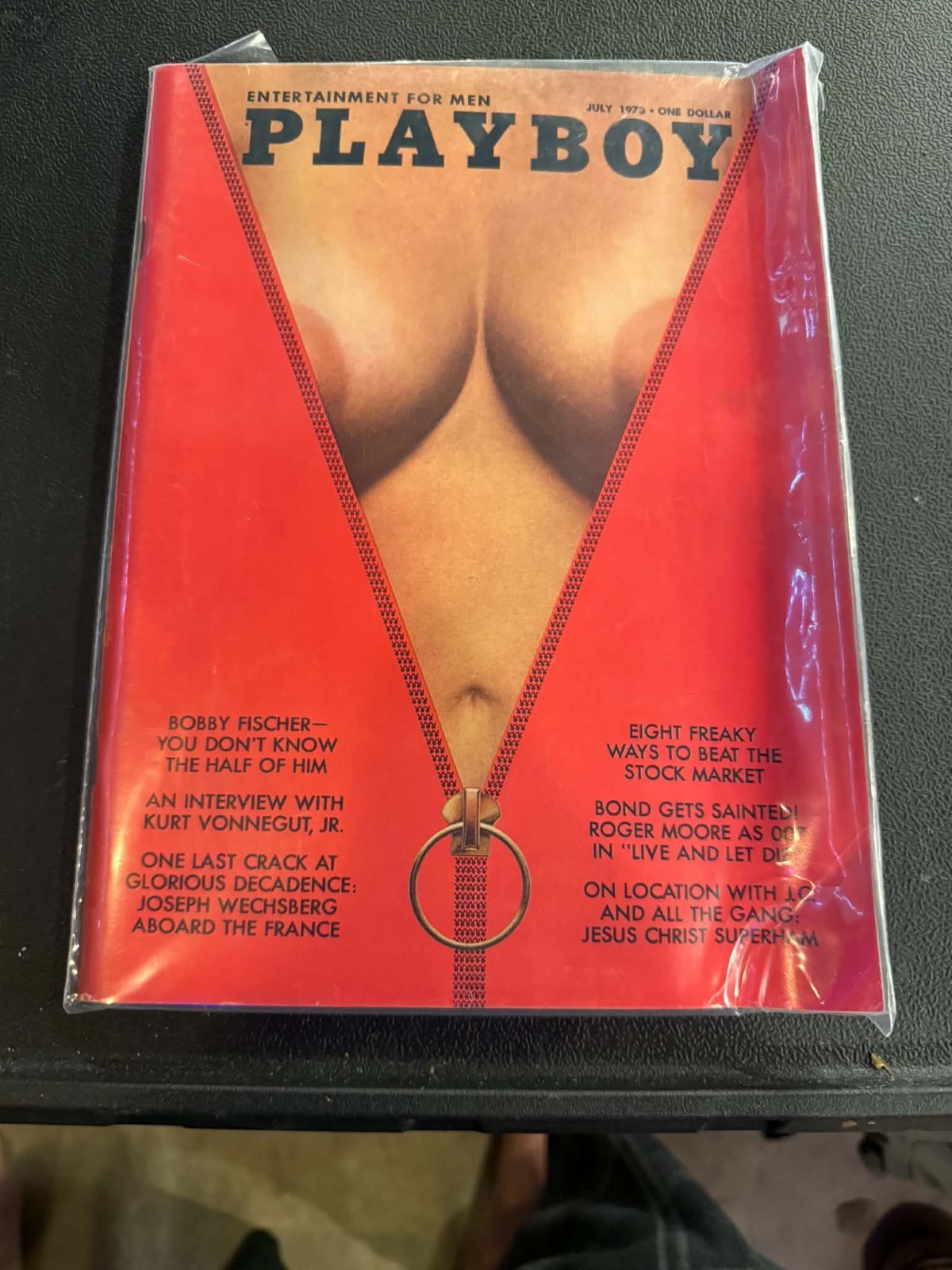 Playboy Magazine from July 1973, featuring a distinctive cover with a red zipper Playboy Magazine from July 1973, featuring a distinctive cover with a red zipper