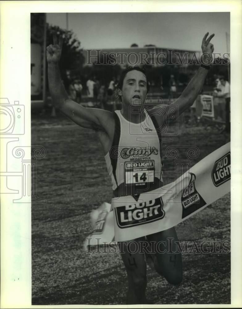 1991 Press Photo Triathlon runner Louis Murphy crosses the finish line in first
