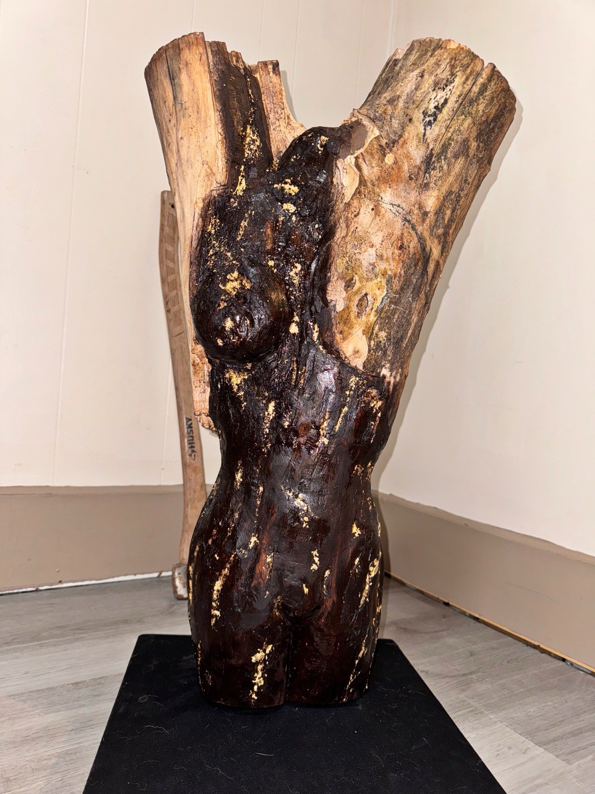 A Women Figure Make Completely Out Of Wood With Gold Foil And A Stained Surface