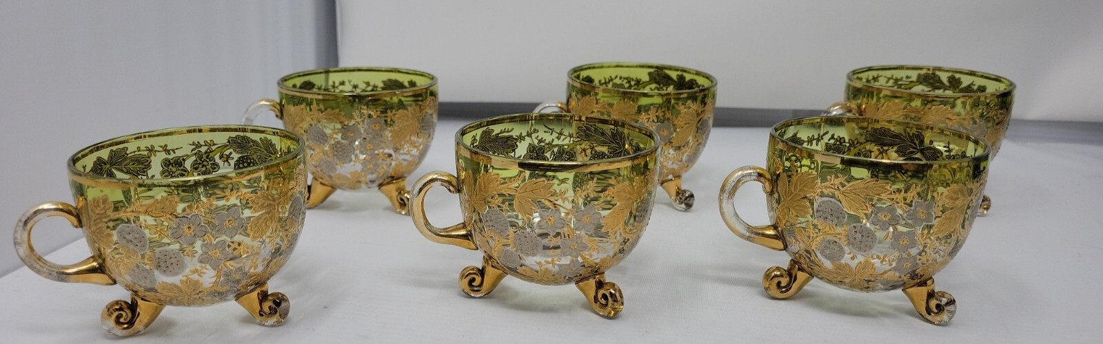 6 ANTIQUE MOSER GLASS 3 FOOTED HANDLED PUNCH CUPS WITH GILT FLORAL AND BERRIES 6 ANTIQUE MOSER GLASS 3 FOOTED HANDLED PUNCH CUPS WITH GILT FLORAL AND BERRIES