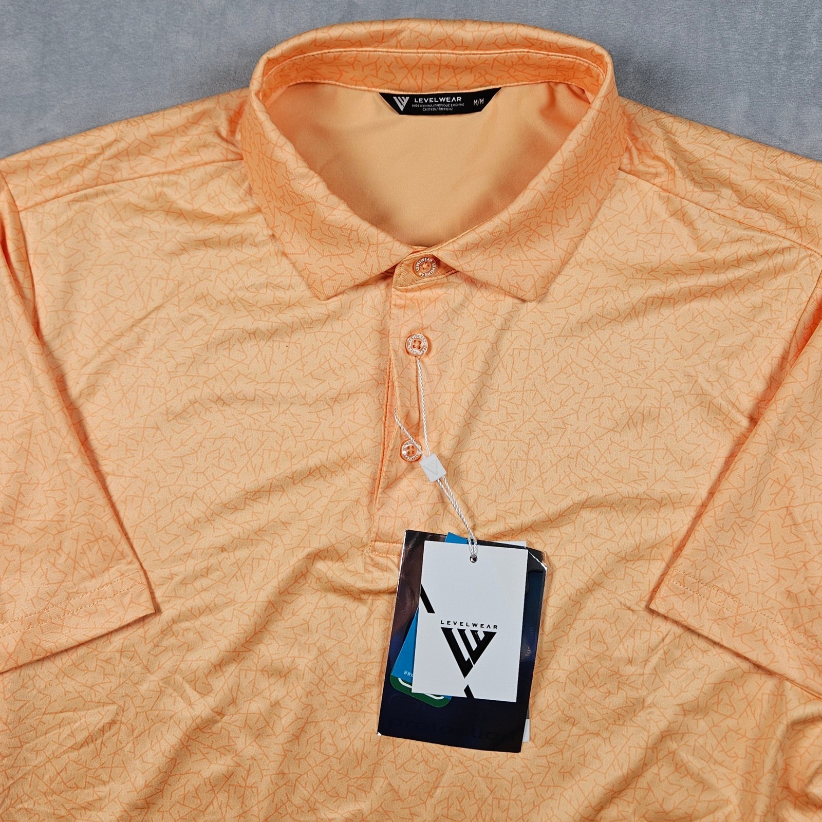 NEW Levelwear Polo Shirt Mens Medium Orange Geometric UPF Moisture Wicking Golf