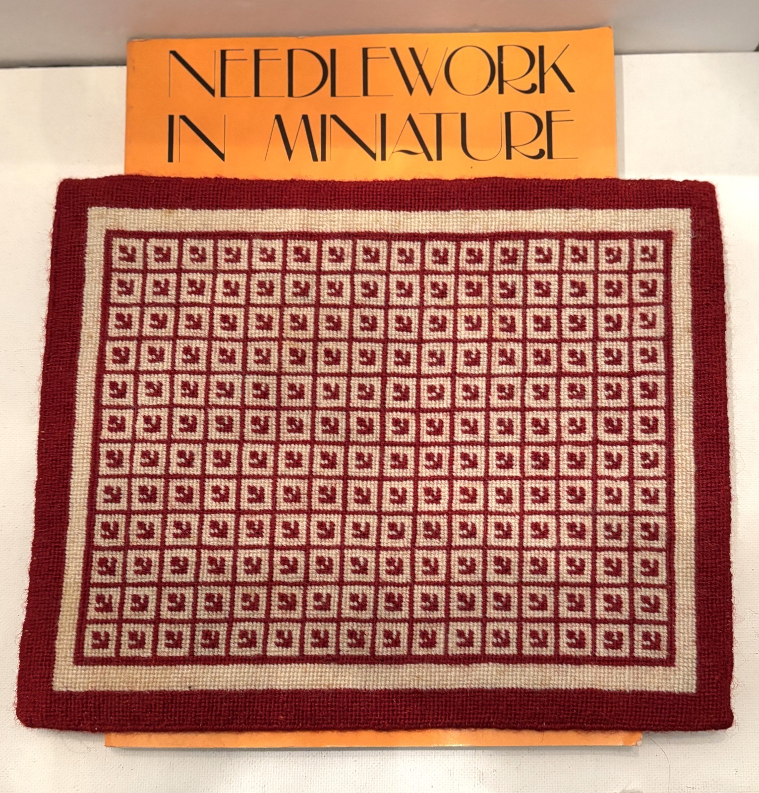 Dollhouse miniature artisan designed and needlepointed rug+book, signed, 1:12