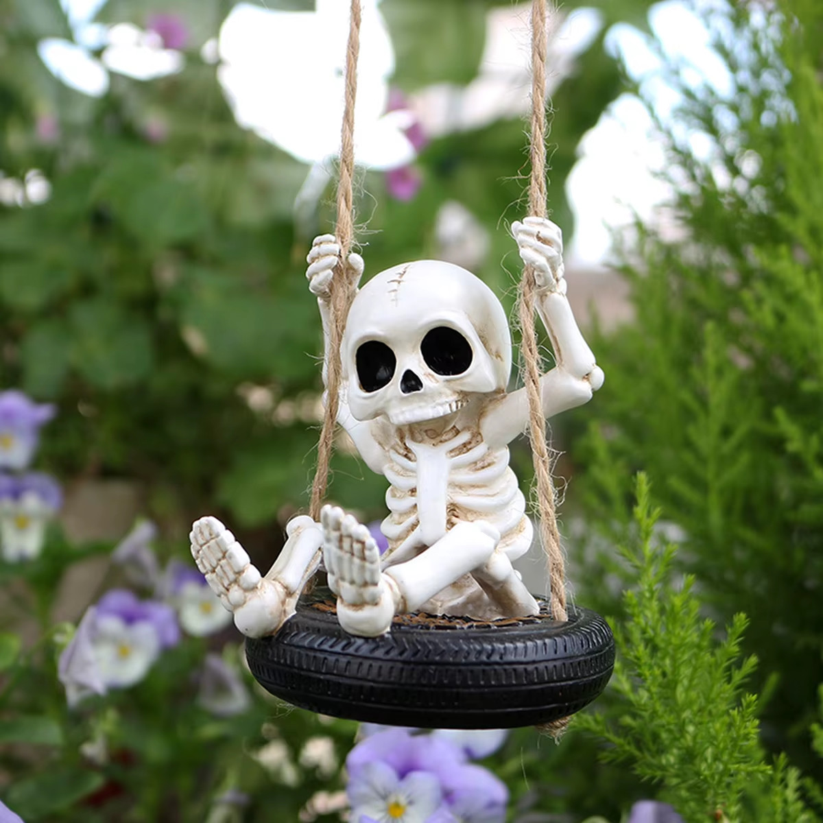 Funny Halloween skeleton riding on a tire swing outdoor garden hanging decor