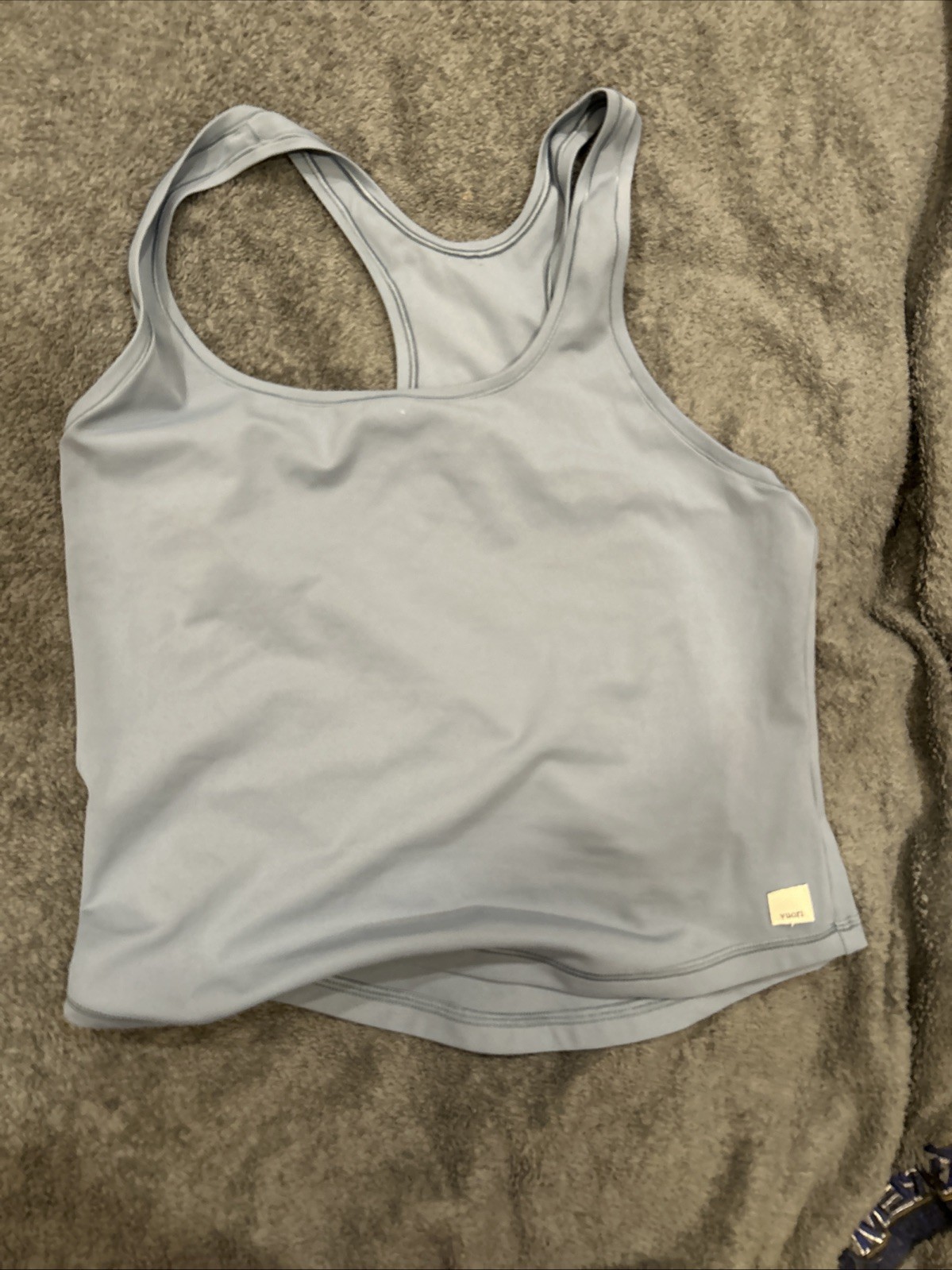 This is a Vuori Feather Slim Racerback Tank Top in a light blue color. This is a Vuori Feather Slim Racerback Tank Top in a light blue color.
