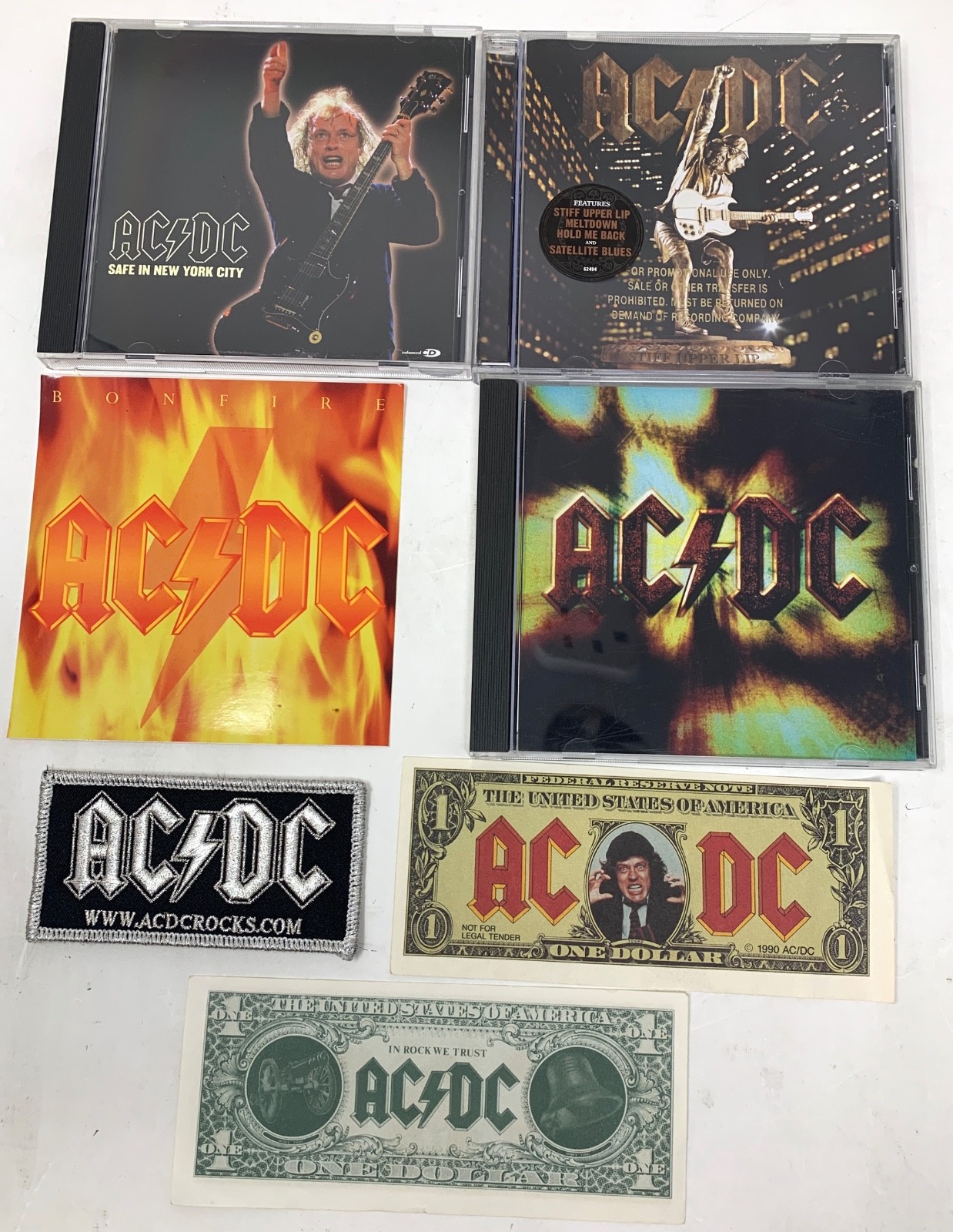 AC/DC Promo Lot - 3 Promo CDs/4 Angus Bucks/Bonfire sticker/Iron-on patch