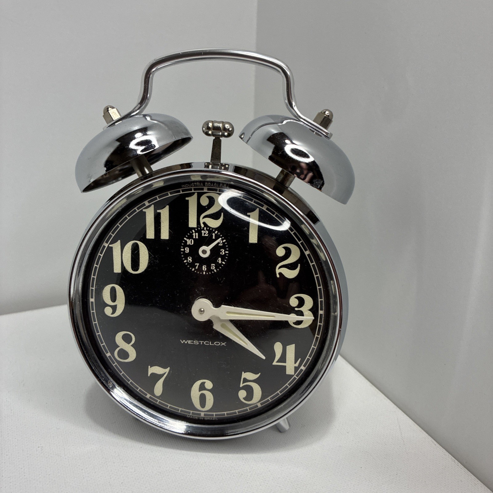 Vintage Westclox twin-bell wind-up alarm clock with a black face and chrome