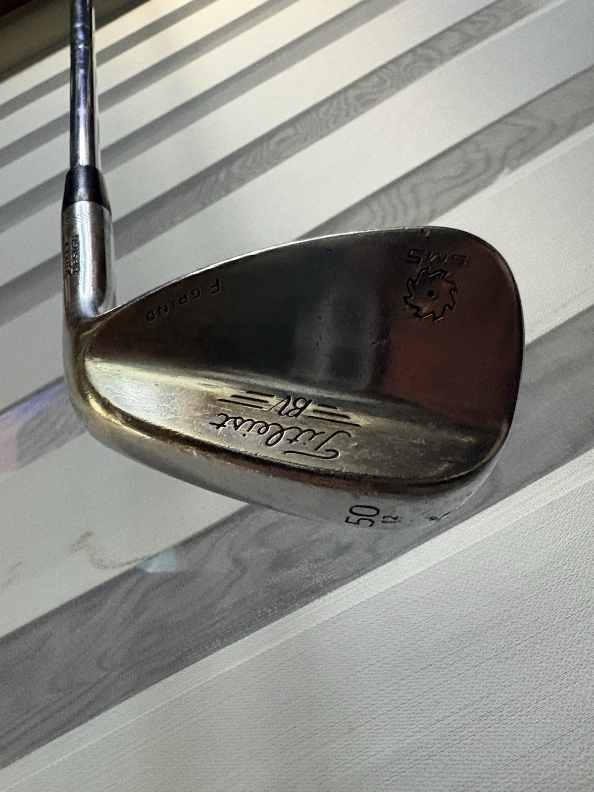 a Titleist Vokey SM5 50-degree golf wedge with an F Grind a Titleist Vokey SM5 50-degree golf wedge with an F Grind