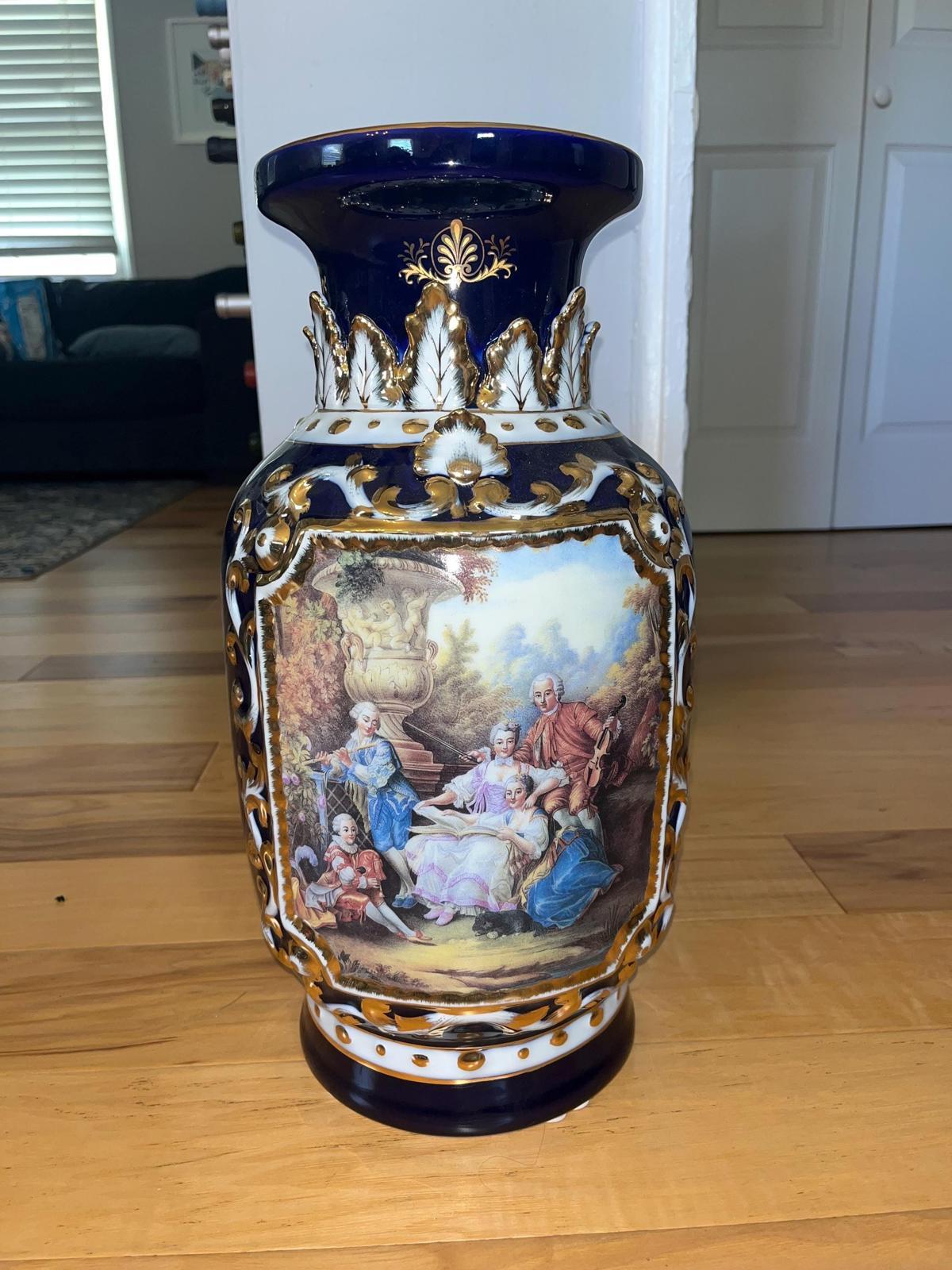 Highly ornate porcelain vase. The dark blue vase is striking and sophisticated. 