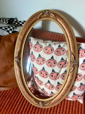 large oval ornate frame with bubble glass picture