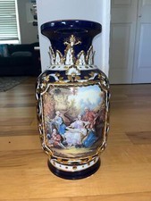 Highly ornate porcelain vase. The dark blue vase is striking and sophisticated.  picture